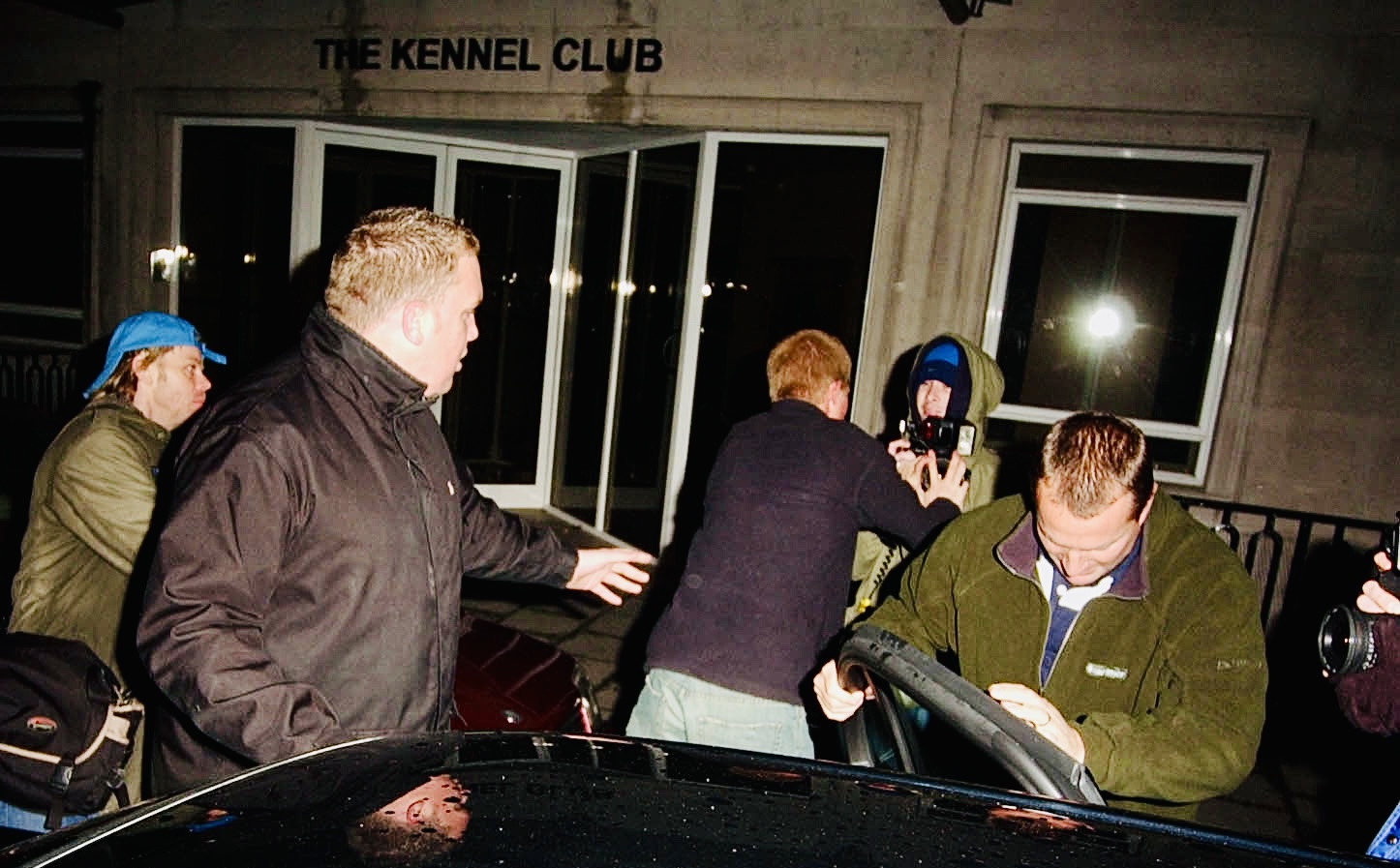 Establishing Moment

(Prince Harry re-emerging from the vehicle)

Prince Harry unexpectedly jumps back out of the car as his security faces the opposite direction. From the first frame, the movement appears deliberate rather than defensive setting the tone for what follows.
