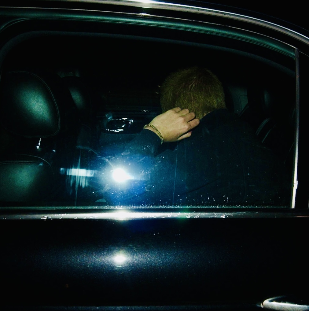 Inside the Vehicle

Prince Harry was seated inside the car following the altercation, hand to head. The adrenaline has passed; the incident is already over.
https://www.cbsnews.com/news/prince-harry-scuffles-with-photog/
